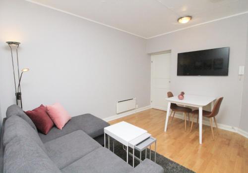 a living room with a couch and a table at Nordic Host - City Center 2 Bed / 2 Bath - Skippergata - 3 minutes from station in Oslo