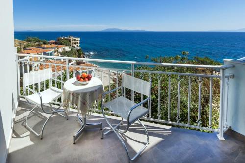 a balcony with a table and chairs and the ocean at Frini Studios in Plomarion