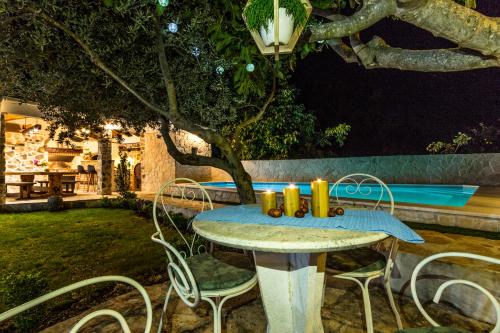a table with candles on it in a yard at night at Villa Andrija in Šibenik