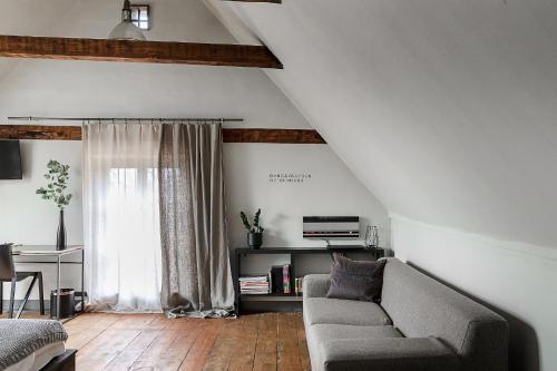 a living room with a couch and a window at Noliktava No 5 in Kuldīga