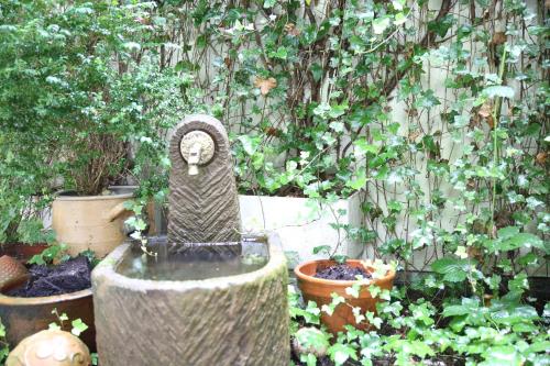 a bird statue in the middle of a garden at Hotel Pilar Garni in Cologne