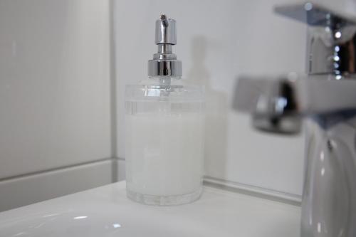 a soap dispenser sitting on top of a bathroom sink at Hotel Pilar Garni in Cologne