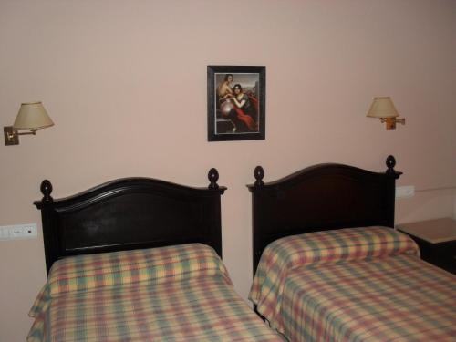 two beds sitting next to each other in a room at Hostal San Luis in Almodóvar del Río