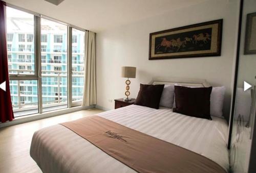 a bedroom with a large bed and a large window at AZURE C5 MAN-MADE BEACH BALCONY Multiple Units in Manila