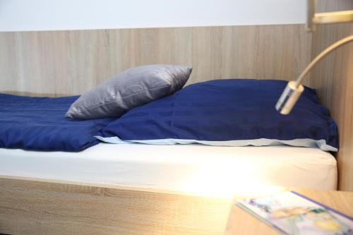 a bed with blue pillows on top of it at Hotel Pilar Garni in Cologne