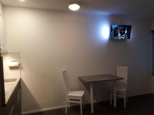 a room with a table and two chairs and a picture on the wall at Vuokatti Slope Suite in Vuokatti
