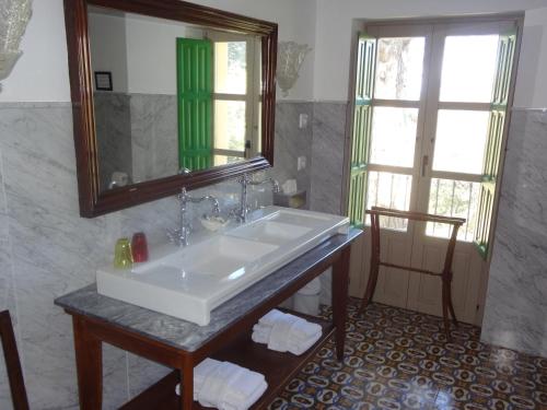 Riola San Gabriel في Alcolecha: حمام مع حوض أبيض ومرآة