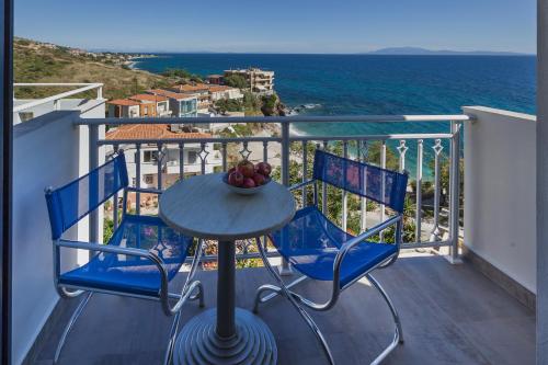 a table and chairs on a balcony with the ocean at Frini Studios in Plomarion