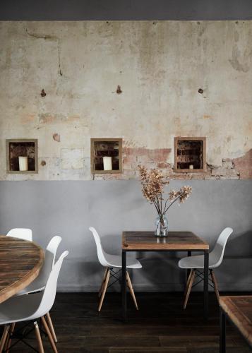 a dining room with a wooden table and white chairs at Noliktava No 5 in Kuldīga