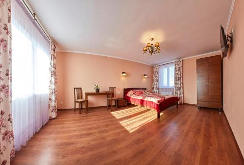 um quarto com uma cama, uma mesa e uma janela em Villa Bozena em Truskavets