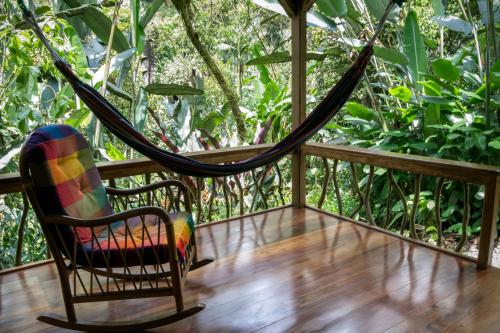 a hammock on the porch of a house at Casa Divina Eco Lodge in Mindo