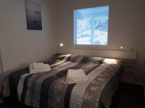 een slaapkamer met een bed met twee handdoeken erop bij Vuokatti Slope Suite in Vuokatti