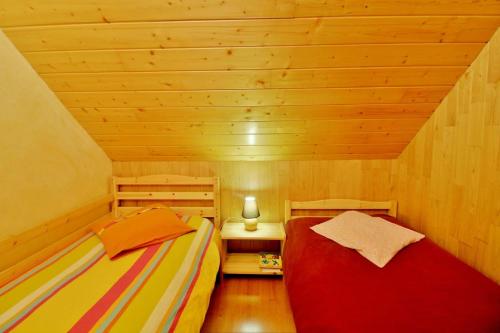 アラヌエにあるAppartement à la montagneの木製天井の小さな部屋のベッド2台