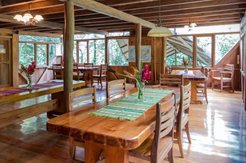 Casa Divina Eco Lodge في ميندو: غرفة طعام مع طاولات وكراسي خشبية