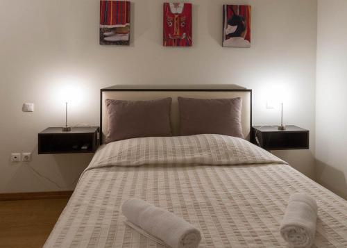 a bedroom with a large bed with two night stands at A Casa do Lagar in São Jorge