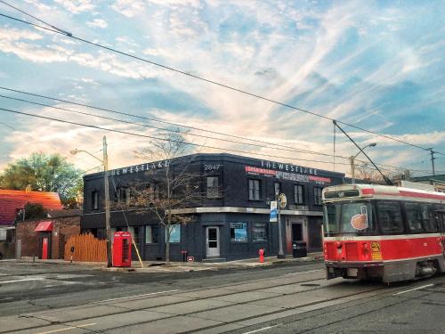 a red bus driving down a street in front of a building at The Westlake in Toronto