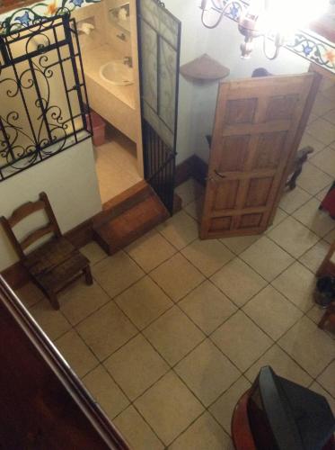 a bathroom with a sink and a cabinet and a chair at Hotel Los Escudos in Pátzcuaro