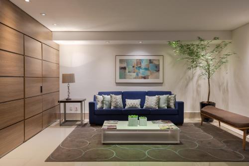 Hotel Heritage في ساو باولو: غرفة معيشة مع أريكة زرقاء وطاولة