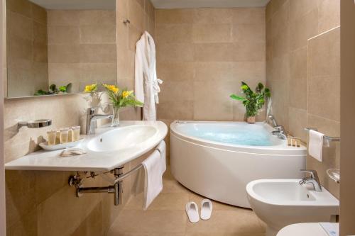 e bagno con vasca, servizi igienici e lavandino. di Grand Hotel Fleming by OMNIA hotels a Roma