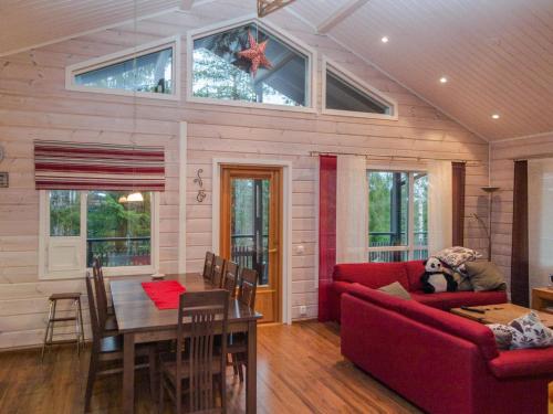 a living room with a red couch and a table at Holiday Home Teerenpesä by Interhome in Tahkovuori