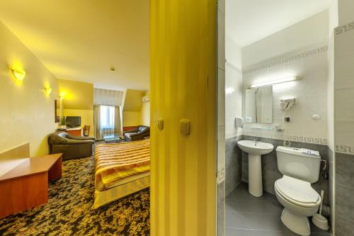 a bathroom with a bed and a sink and a toilet at Hotel Cheap in Sofia