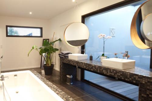 Un baño con bañera, lavabo y espejo. en Villa Margaux, en Fargues-Saint-Hilaire