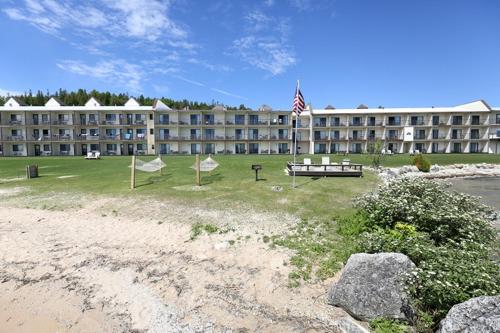 a large building with an american flag in front of it at Bavarian Haus Lakefront Inn in Saint Ignace