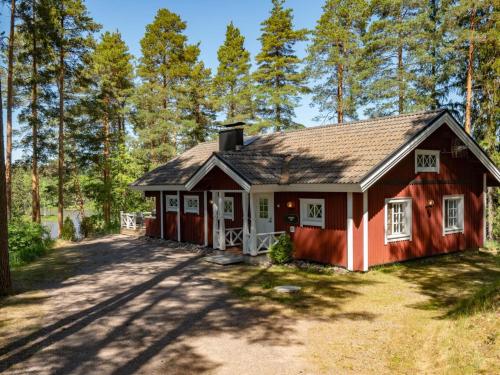 una casa roja en el bosque con árboles en Holiday Home Kivitasku by Interhome, en Hirsjärvi