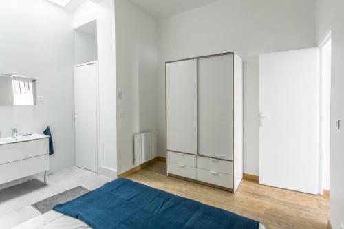 a bedroom with a large white closet and a sink at Appartement Vacances Picardie in Amiens