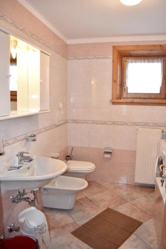 uma casa de banho com um lavatório e um WC em Appartamento Trela 3 em Livigno