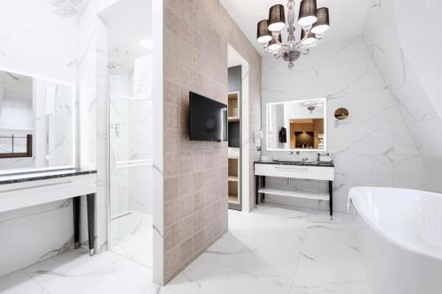 a bathroom with a tub and a sink and a mirror at Grand Park Hotel in Szczecin
