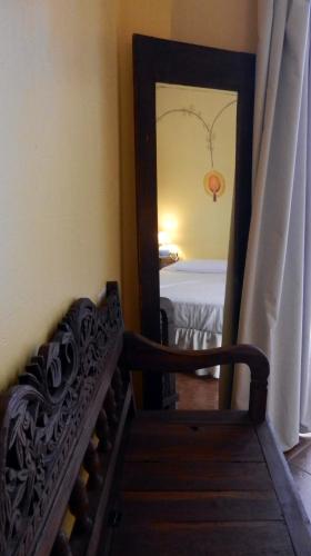 a mirror reflecting a bedroom with a bed in a room at Las Cuatro Calles in Piedralaves