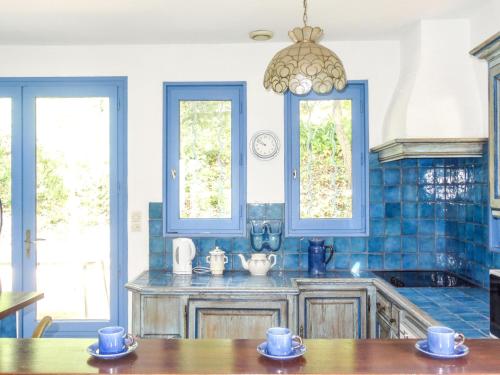 een keuken met blauwe tegels op de muren en ramen bij Holiday Home Le Vent d'Est by Interhome in Saint-Tropez