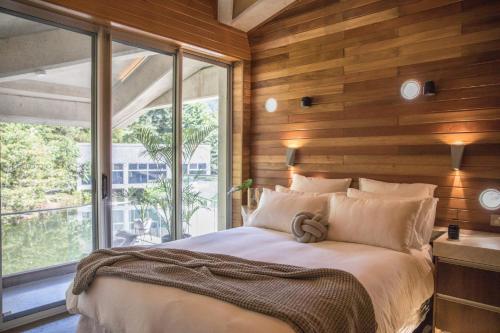 A bed or beds in a room at Alkira Award Winning Luxury Beachfront Rainforest Holiday House