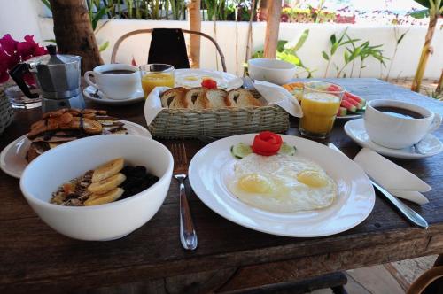 un tavolo con colazione a base di uova, pane e caffè di Beachfront Villa Patti ZanzibarHouses a Kiwengwa