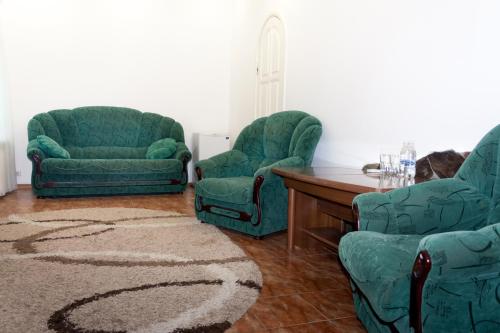 a living room with two green chairs and a table at Fortetsya "Стабільне електропостачання!" in Umanʼ