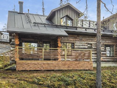 a log cabin with a large deck in front of it at Holiday Home Maahisenrinne 3 f 25 by Interhome in Äkäslompolo