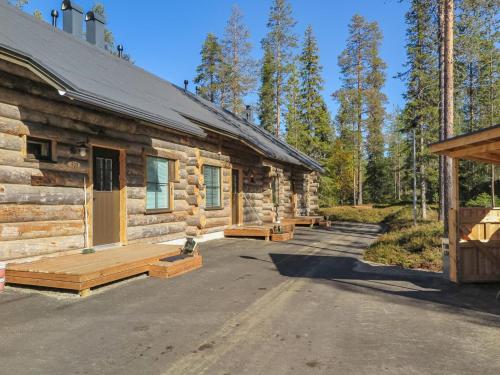 a log cabin with benches in front of it at Holiday Home Maahisenrinne 3 f 25 by Interhome in Äkäslompolo