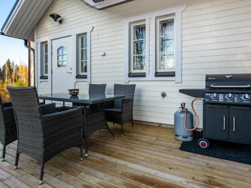 a patio with a table and chairs and a grill at Holiday Home Hovimäki by Interhome in Vähäsalmi