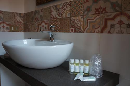 un baño con lavabo blanco y botellas en una encimera en La Scarana, en Ferrara