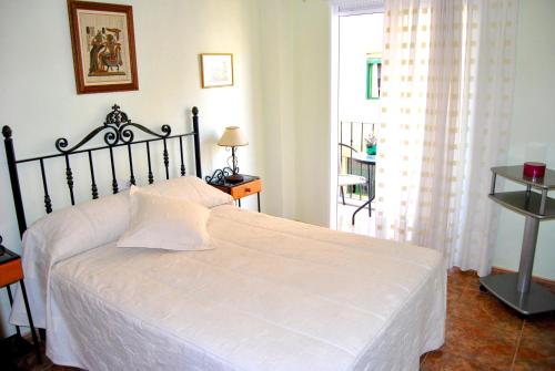 ein Schlafzimmer mit einem weißen Bett und einem Fenster in der Unterkunft RUMOHOLIDAYS Spacious 3 bedrooms apartment Playa del Cura in Torrevieja