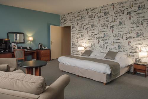 モントルイユ・シュル・メールにあるベストウエスタン ホテル エルミタージュのベッド、ソファ、椅子が備わるホテルルームです。
