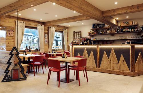um restaurante com paredes e mesas e cadeiras de madeira em Alpen Chalet em Schilpario