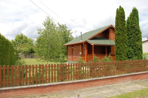 een houten huis achter een houten hek bij Lake House Farsang in Balatonberény