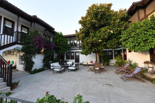 a courtyard of a house with chairs and tables at Villa Konak Hotel in Kusadası