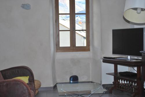 a living room with a tv and a glass table at Gite Cap de la Hont in Laruns