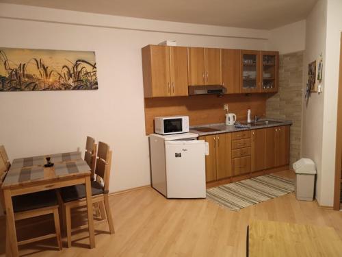 a kitchen with a table and a white refrigerator at Telgárt Apartmán č.12 in Telgárt
