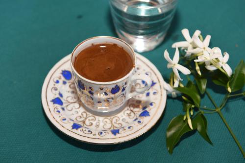 a cup of coffee on a plate on a table at Villa Konak Hotel in Kusadası