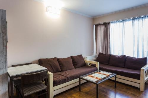a living room with a couch and a table at APT 7 Mgzavrebi in Bakuriani