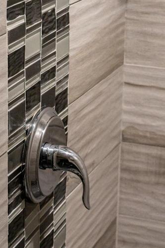 a shower door with a metal door handle at Hotel et Motel Le Chateauguay in Quebec City